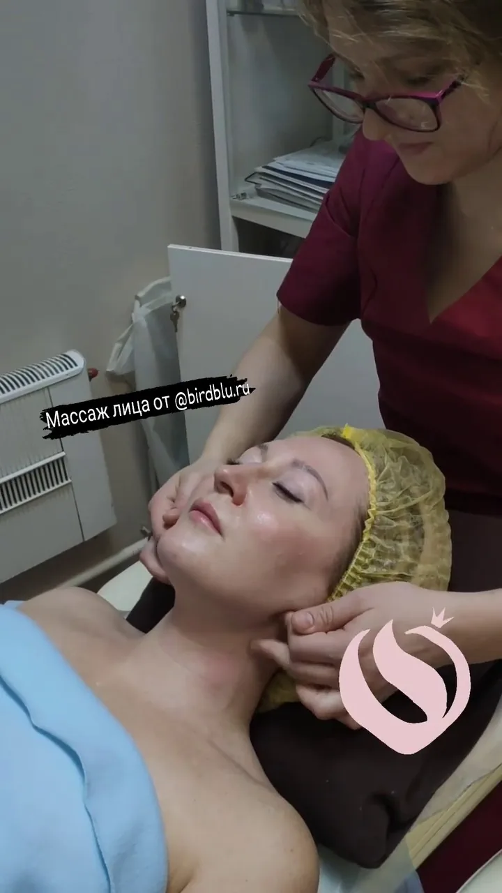 Женщина проходит массаж лица в клинике, процедура лимфодренажного ухода