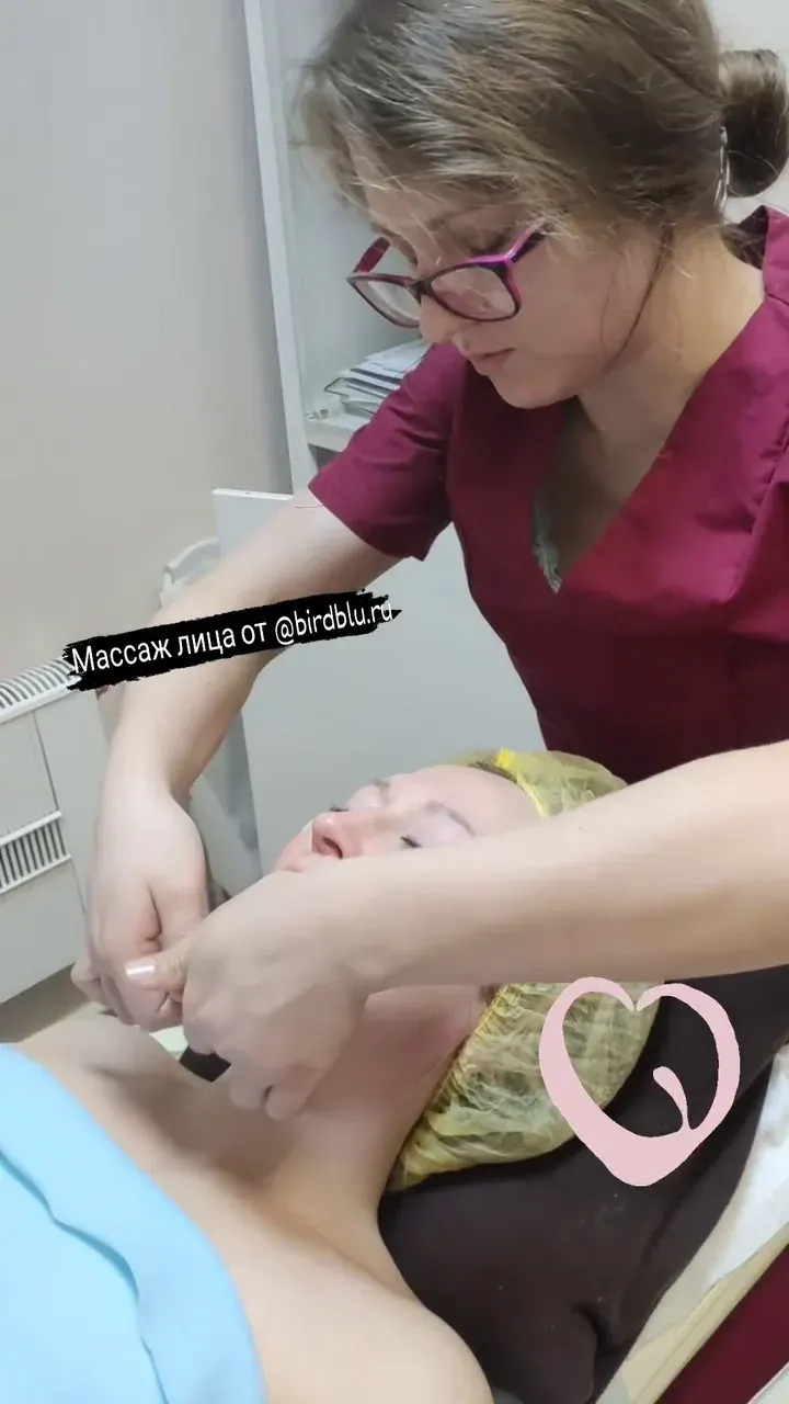 Специалист выполняет массаж лица пациентке на кушетке в клиническом кабинете Специалист выполняет массаж лица пациентке на кушетке в клиническом кабинете