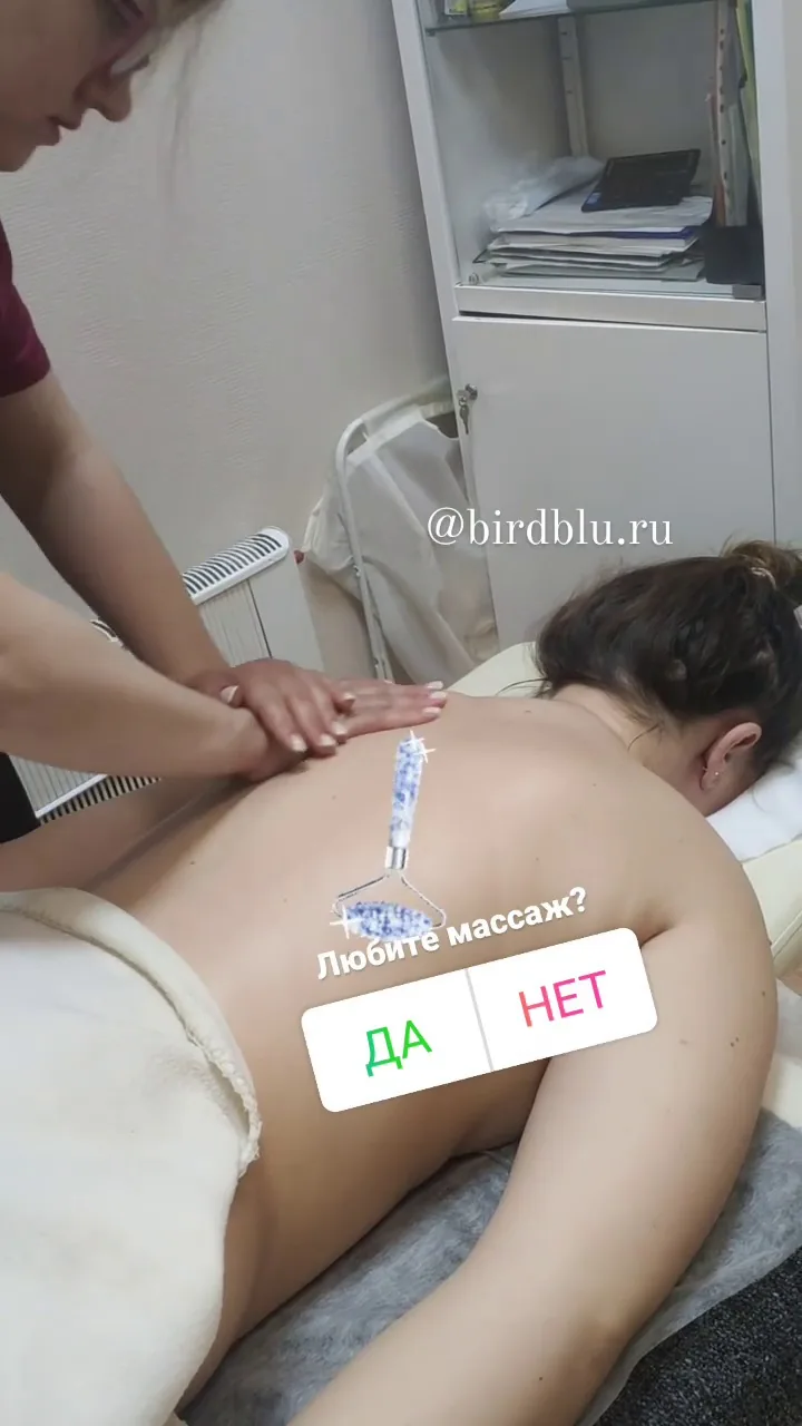 Массажист делает расслабляющий массаж спины с небольшими охлаждающими аппликаторами в верхней части спины